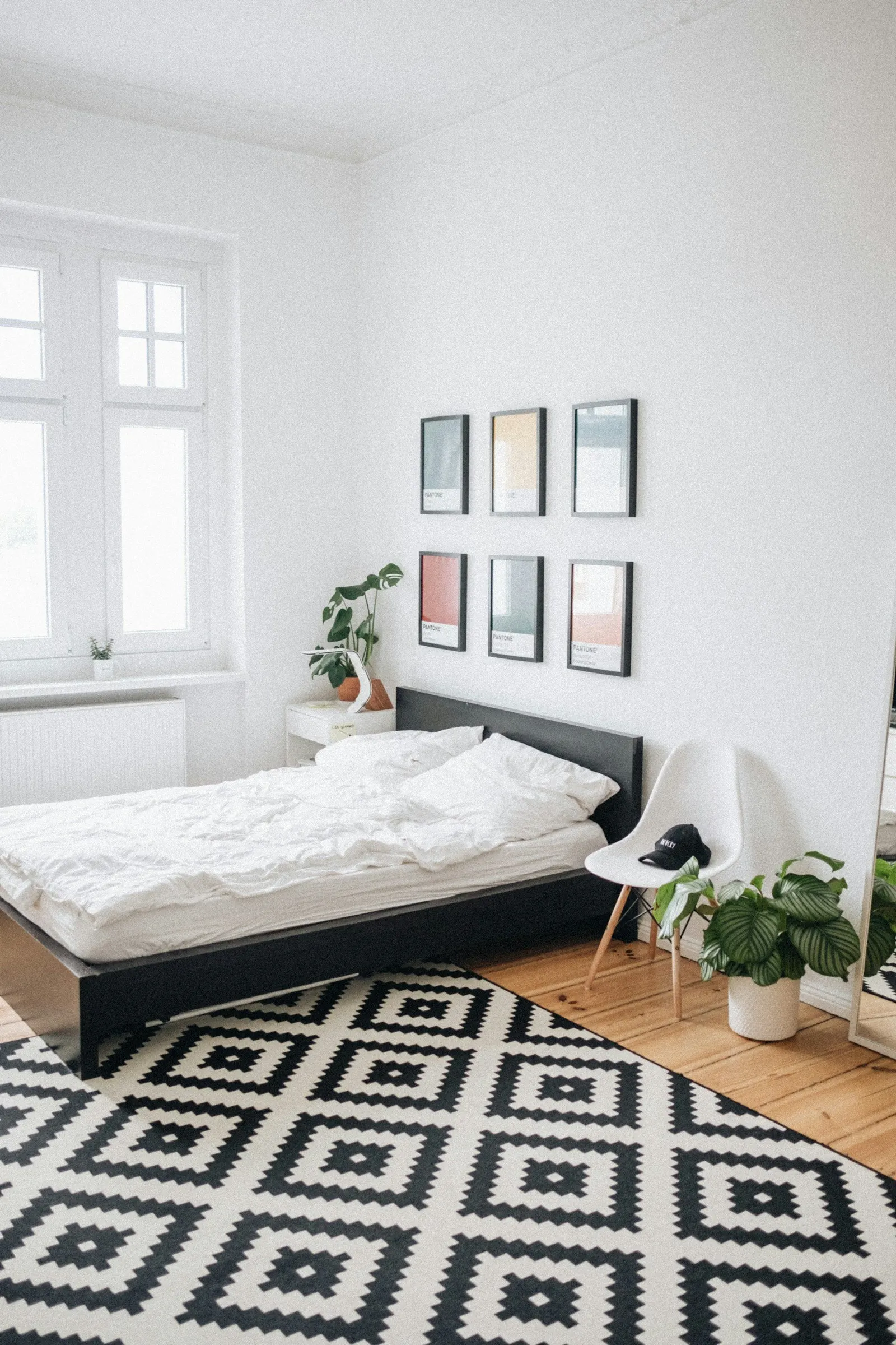 Lyst rom med seng og bilder på veggen